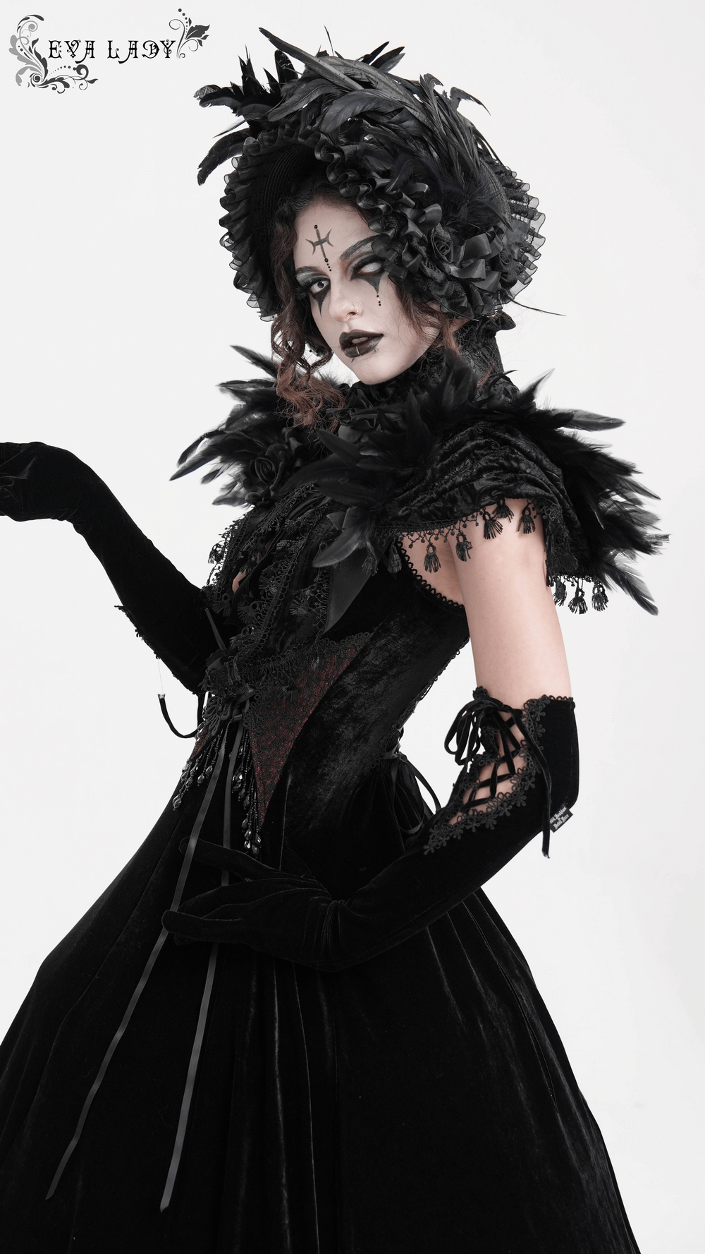 Gothic model showcasing a dramatic feathered cape with lace details and a stylish hat, exuding Victorian elegance.