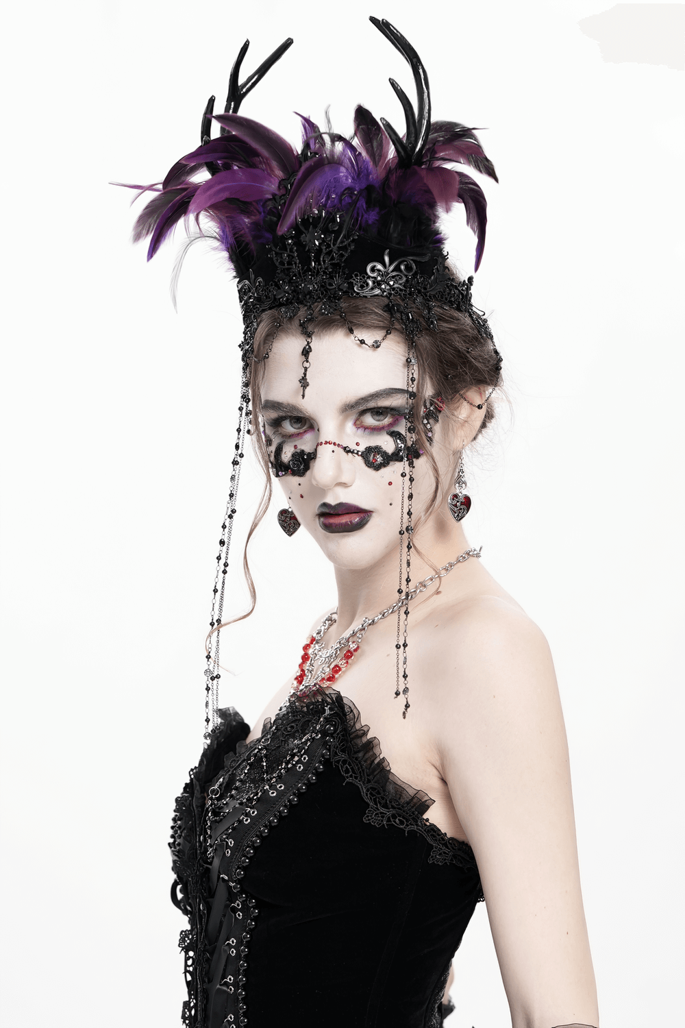 Gothic feathered headpiece with purple and black feathers, adorned with chains and cross ornaments.