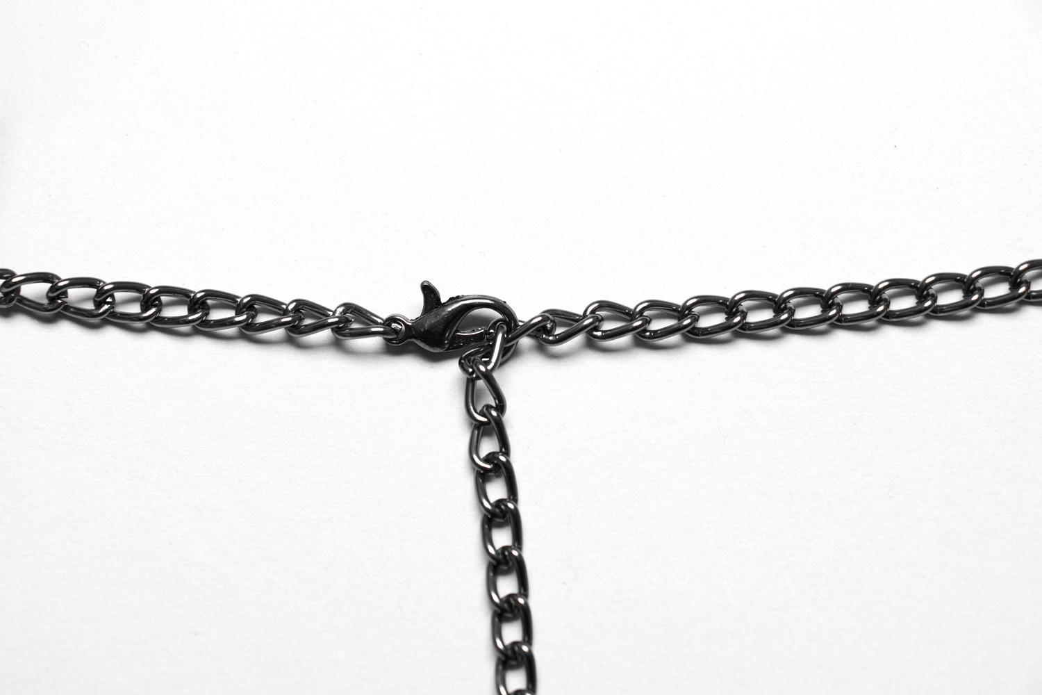 Close-up of a black choker necklace with a clasp and chain detail for gothic fashion.