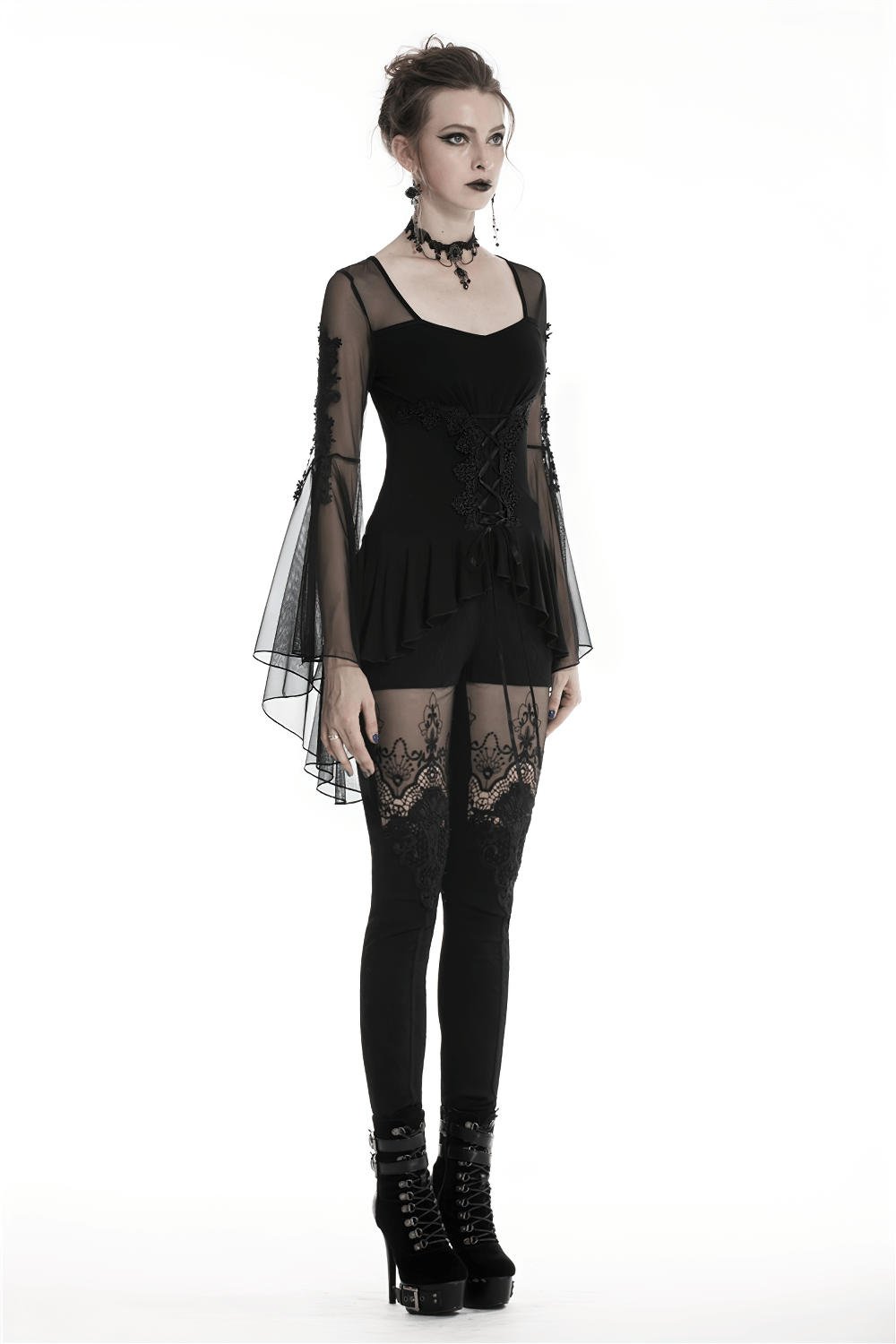 Gothic female model in lace-up ruffled top with sheer sleeves and legging, exuding a dark and elegant vibe.