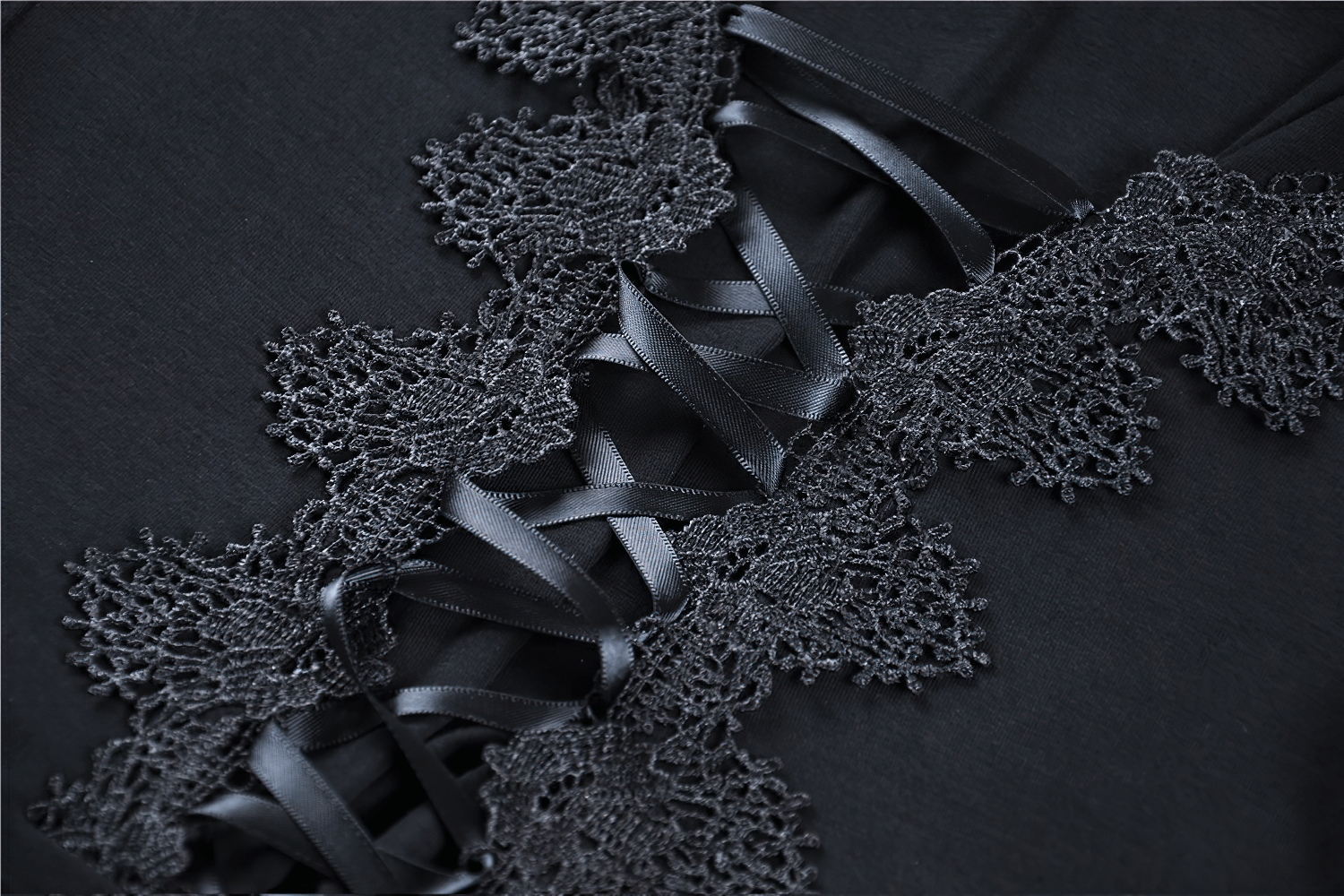 Close-up of intricate lace details and lace-up ribbons on a gothic female top, showcasing elegance and mystery.