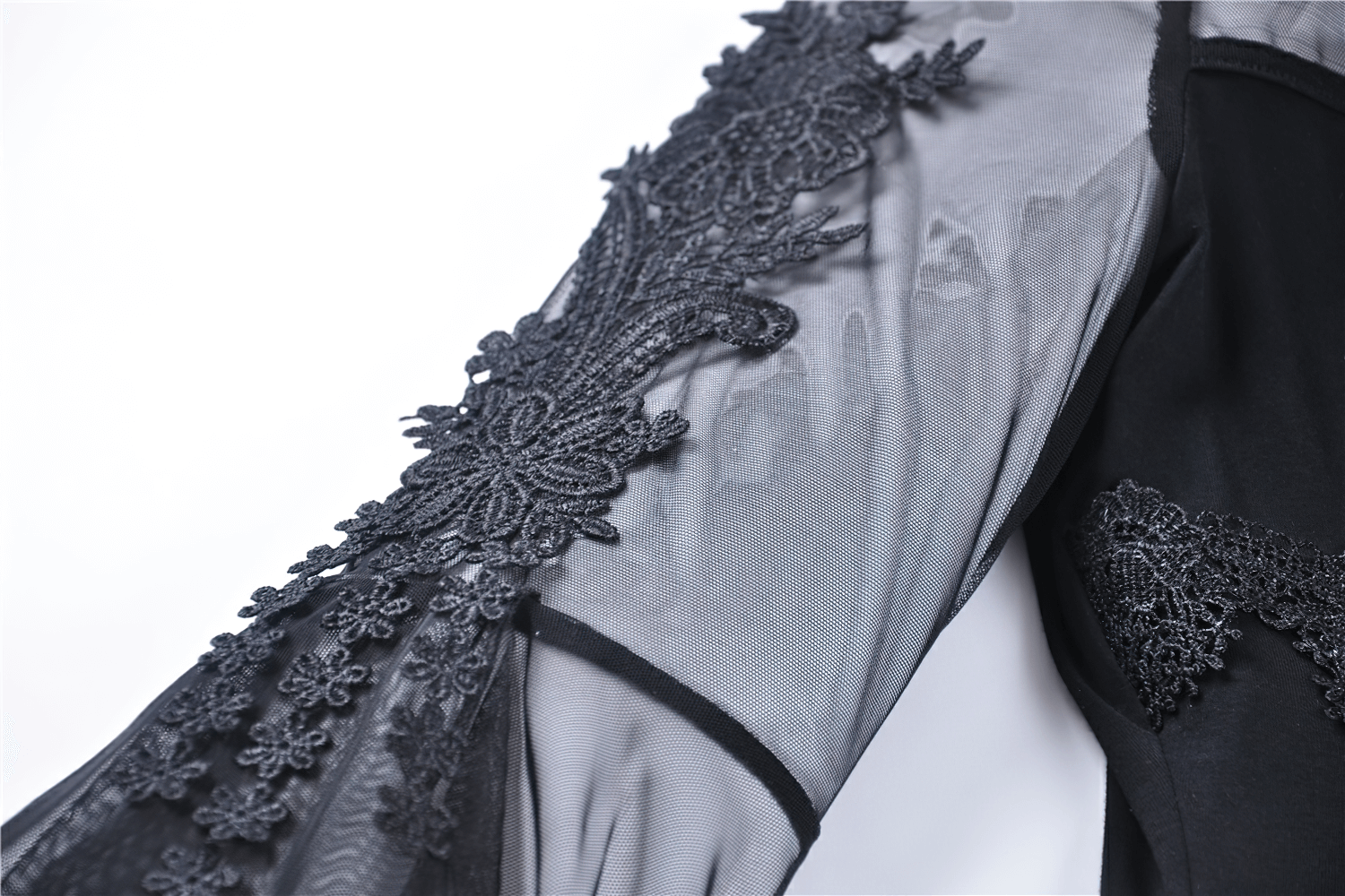 Close-up of gothic female lace-up top with sheer sleeves and intricate black lace detailing.