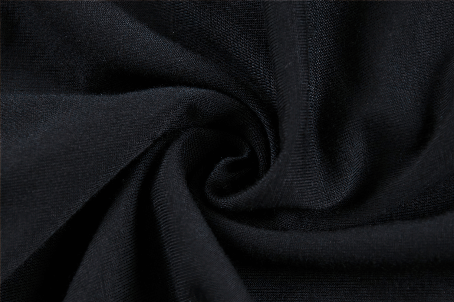 Close-up of dark black fabric, showcasing a soft and smooth texture ideal for gothic fashion tops.