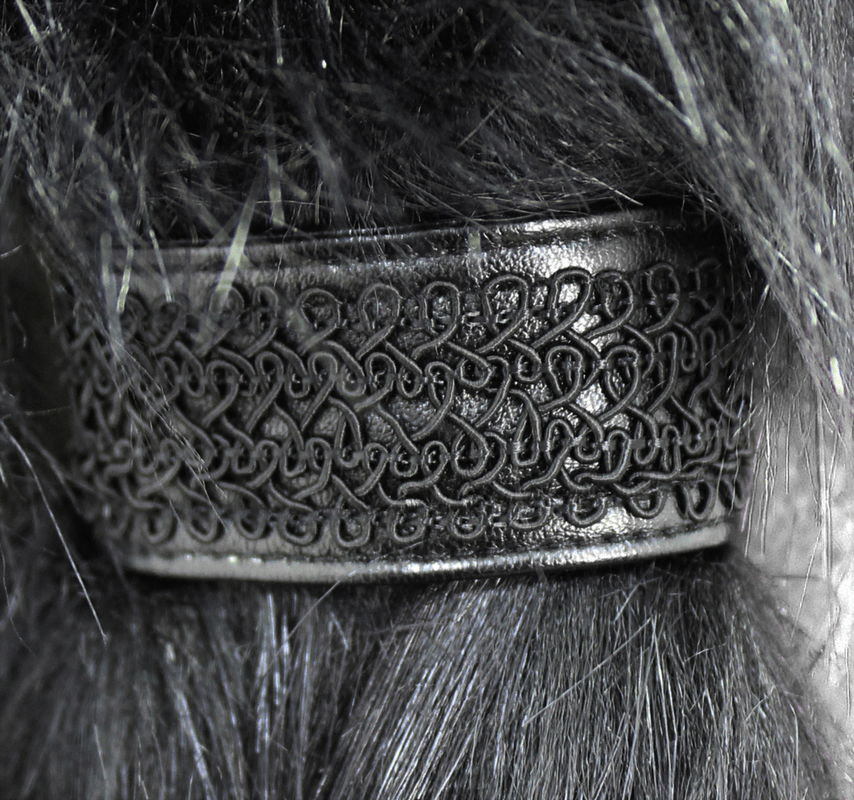 Close-up of a decorative black hair band with intricate patterns, perfect for alternative and gothic styles.
