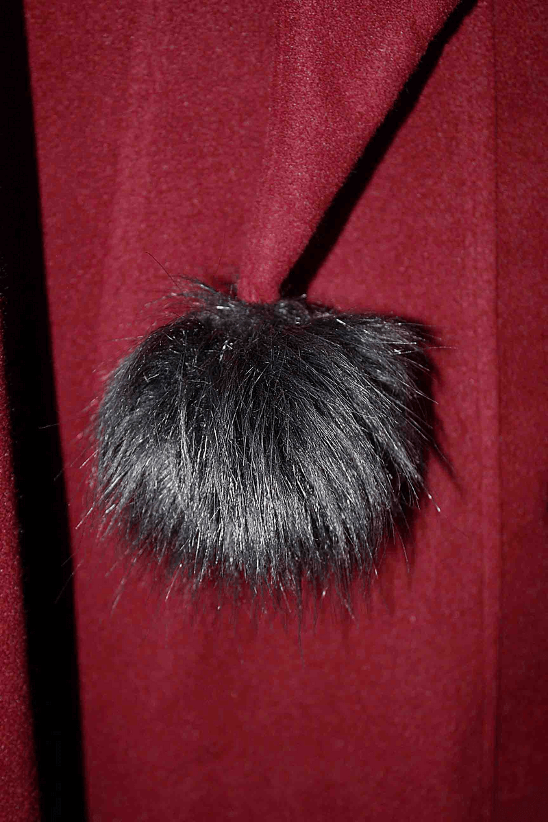 Close-up of the removable black fur collar on a vintage gothic red coat for women.