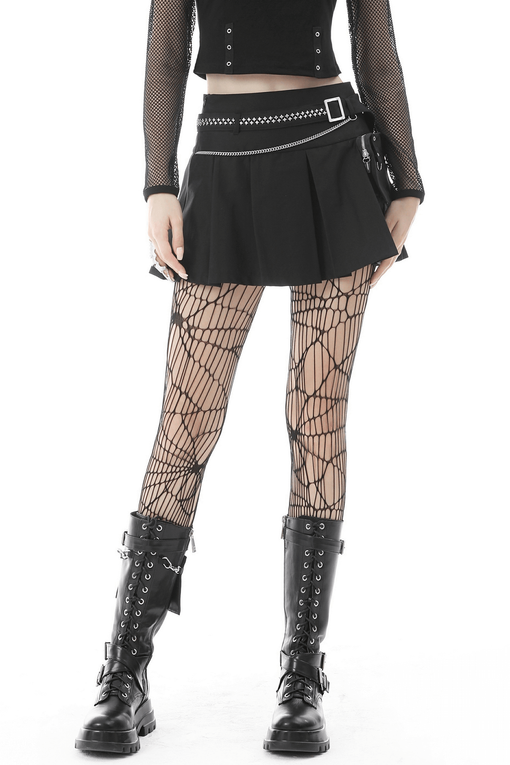 Gothic female model wearing a black pleated mini skirt with chain belt and fishnet stockings, showcasing punk style.