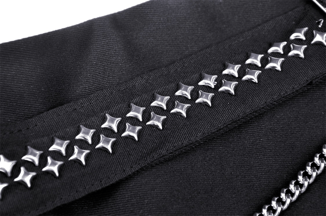 Close-up of black fabric featuring silver studs and chain, adding punk flair to a Gothic mini skirt.