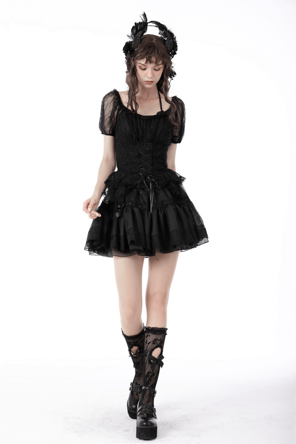 Gothic female model in sheer black lace top with puff sleeves and layered black skirt, showcasing a dramatic vintage-inspired look.