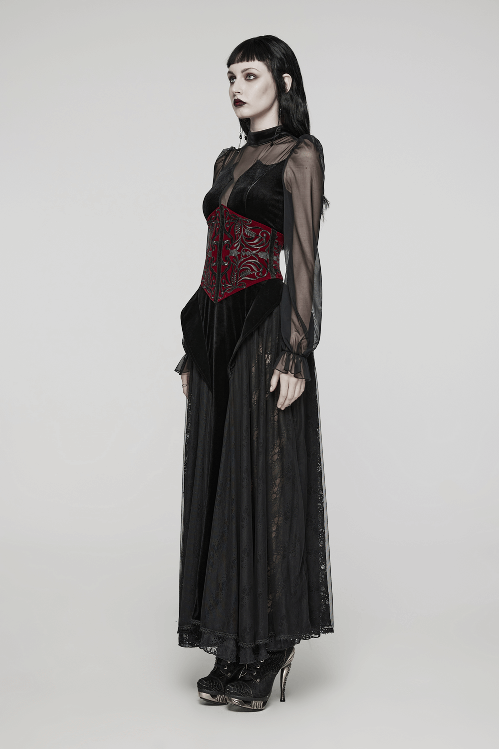 Gothic female model in black dress featuring a velvet corset waistband with red floral embroidery.