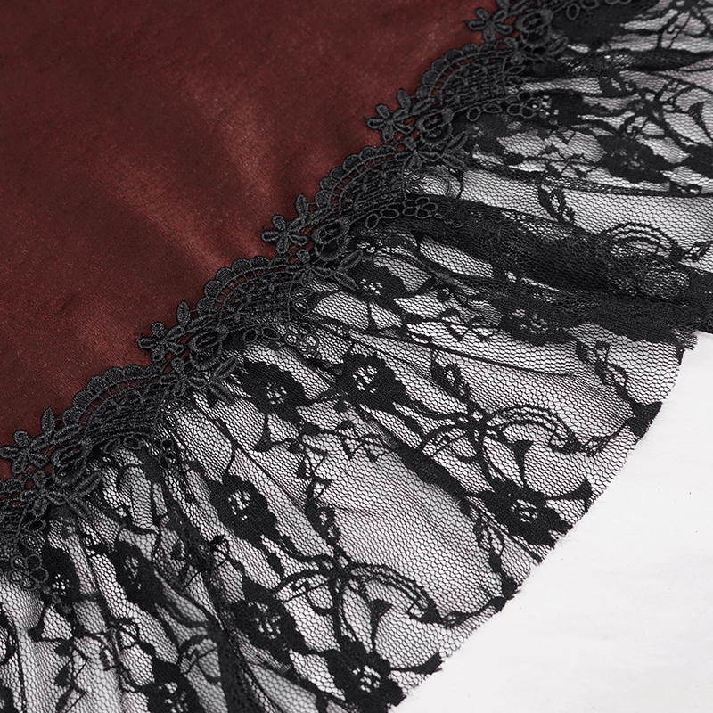 Close-up of gothic lace trimming on wine red vintage dress, showcasing intricate black lace details.