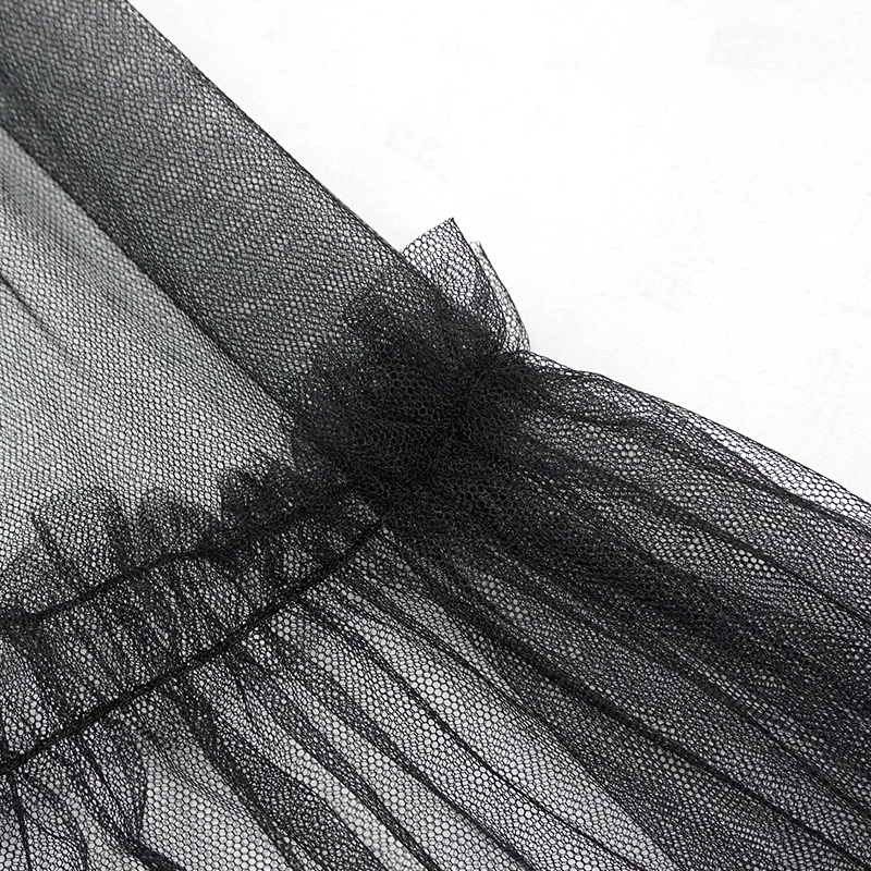 Close-up of black lace fabric showcasing delicate ruffles and texture for gothic fashion design.