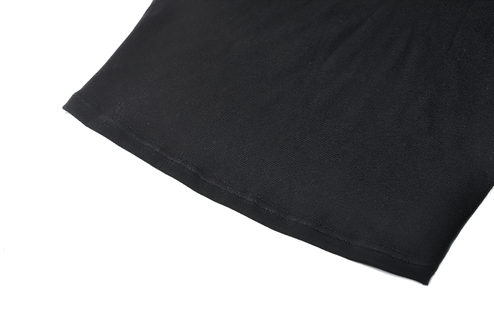 Close-up of the hem of a black top, showcasing smooth fabric texture and tailoring details for a polished look.