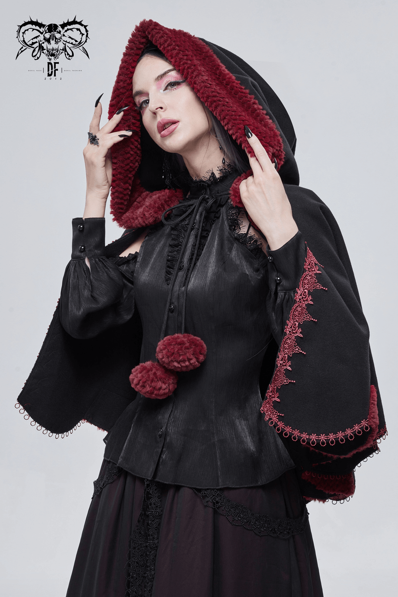 Gothic floral embroidered black cape with red pompons and hood worn by a model, showcasing vintage style.