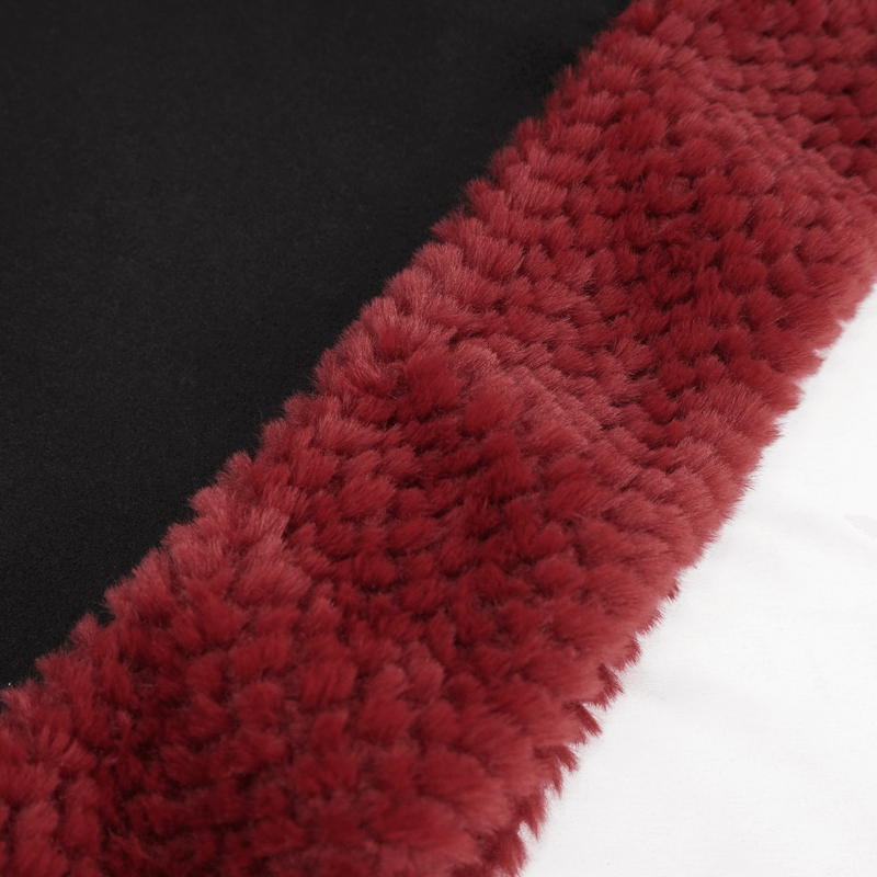 Close-up of black fabric with a plush red pompon trim, perfect for a gothic floral embroidered cape.