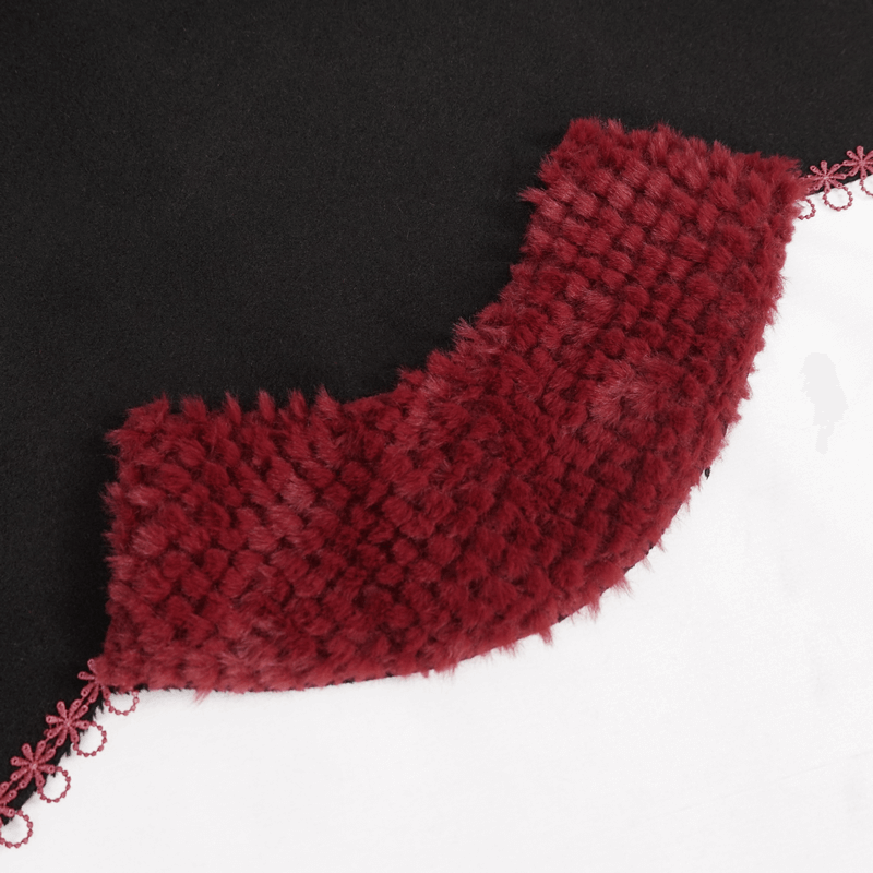 Close-up of black gothic cape featuring red pompons and guipure trim for a stylish accent.