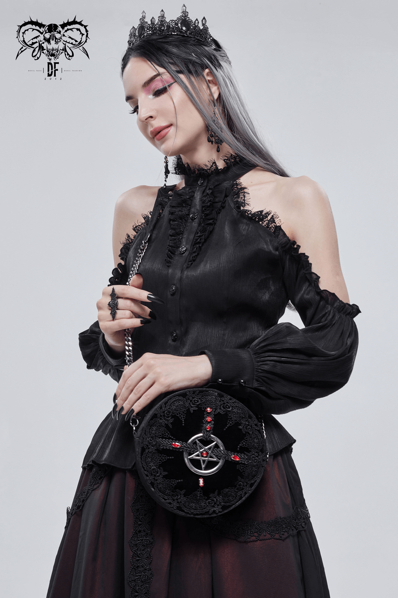 Elegant woman in black gothic blouse holding a round bag with guipure and red gems, featuring a pentagram design.