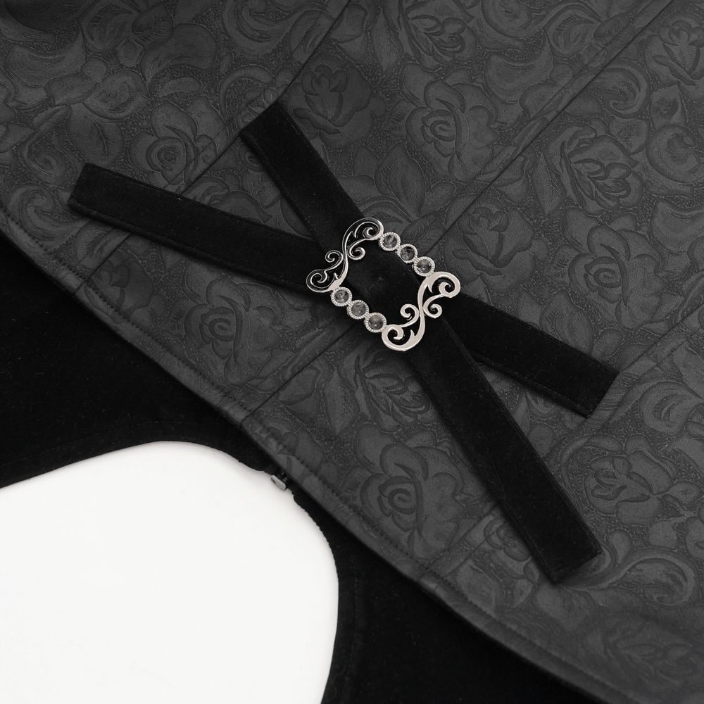 Close-up of black gothic waistcoat with floral pattern and velvet straps featuring a decorative cross buckle.