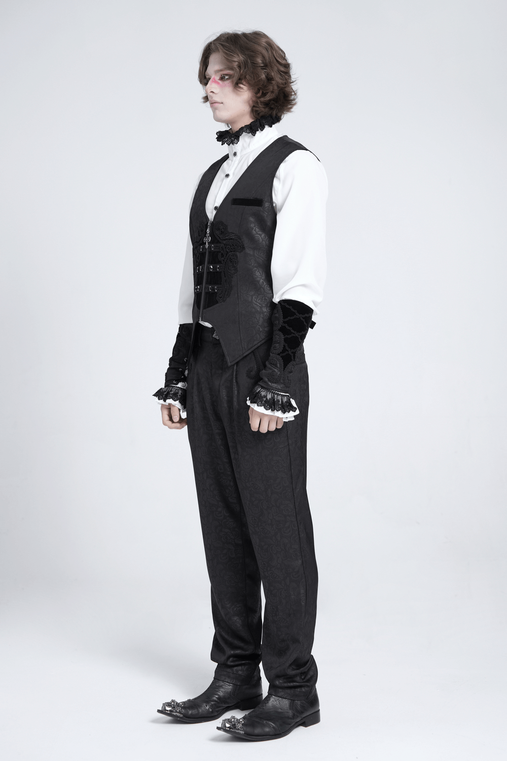 Model wearing a Gothic floral waistcoat with velvet straps and cross detail, showcasing dark elegance and Victorian style.