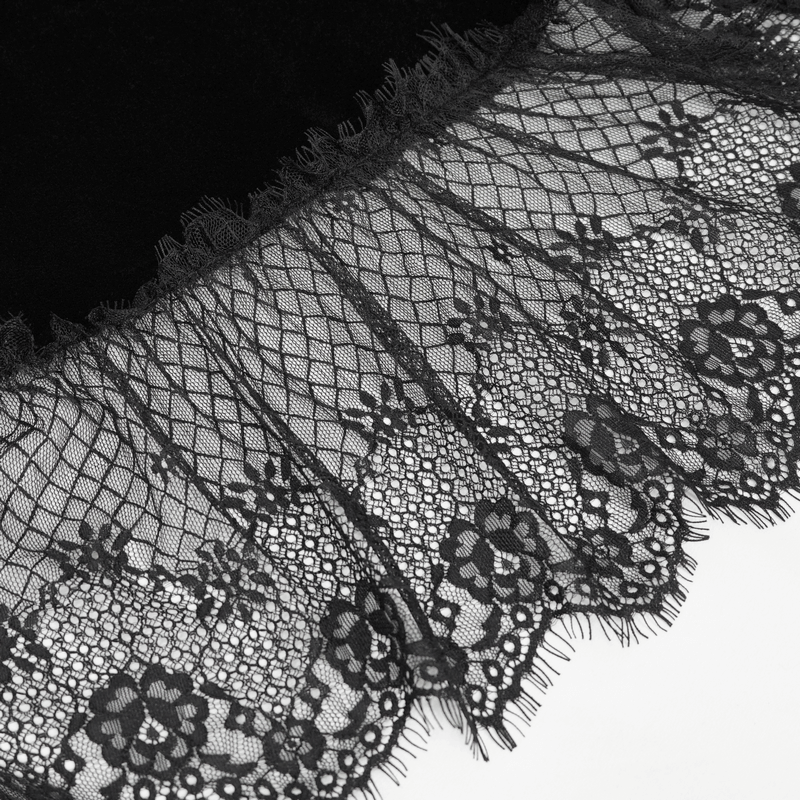 Close-up of intricate black lace hem design on a gothic velvet dress, showcasing detailed floral patterns.
