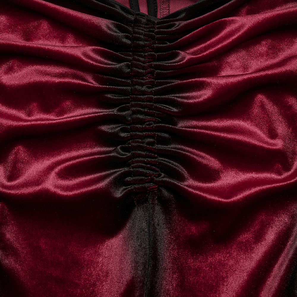 Close-up of plush velvet fabric with intricate ruched detailing in deep burgundy and black, showcasing luxurious texture.