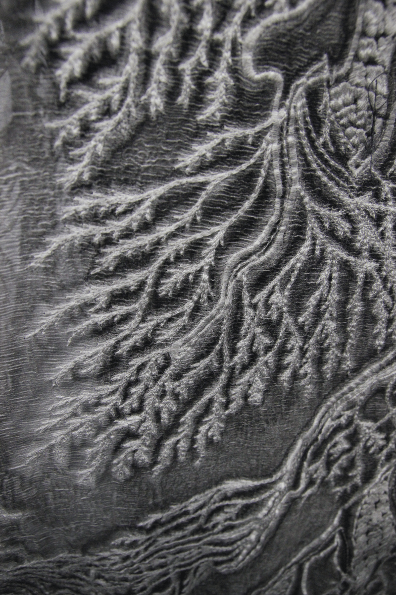 Close-up of intricate gothic pattern in grey fabric, showcasing deep textures and vintage-inspired designs.