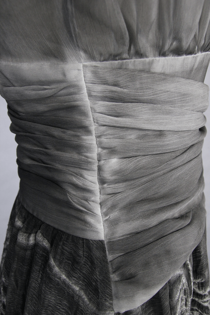 Close-up of the elegant ruched design on the back of a gray gothic backless dress for women.