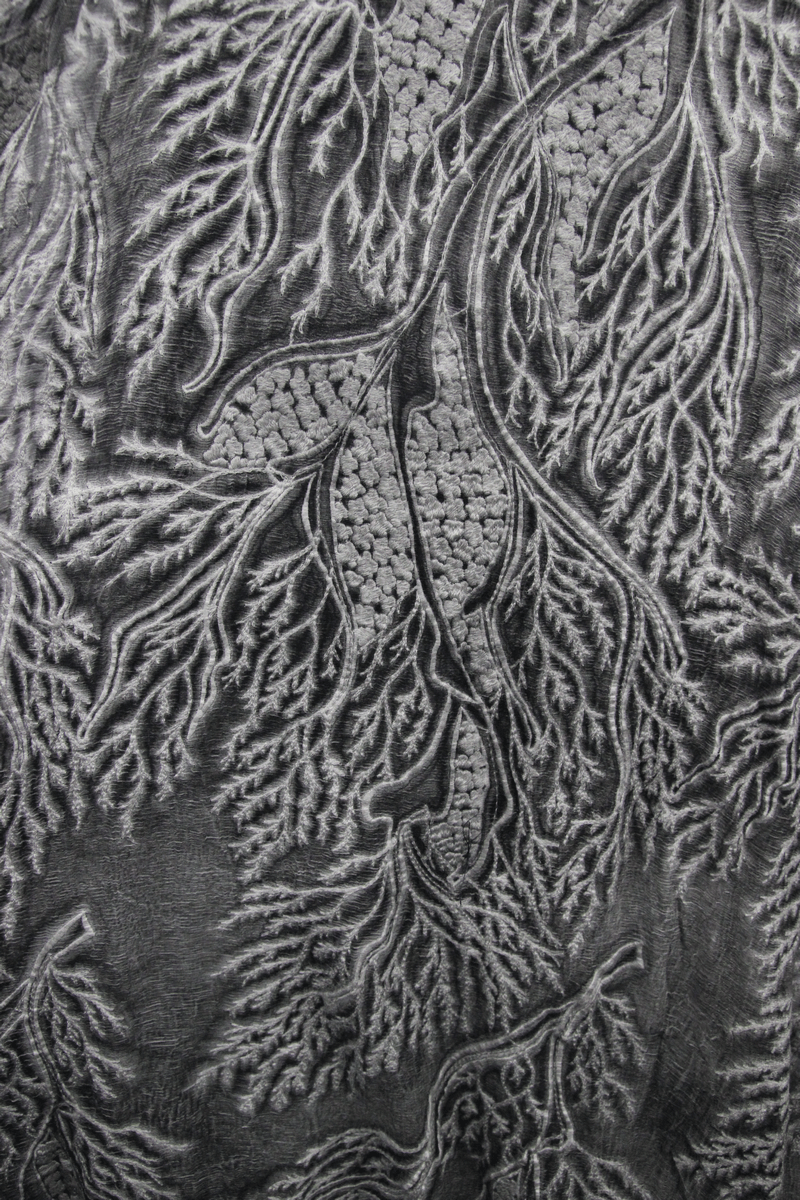 Close-up of intricate gray lace fabric featuring elegant leaf patterns, perfect for gothic or punk fashion dresses.