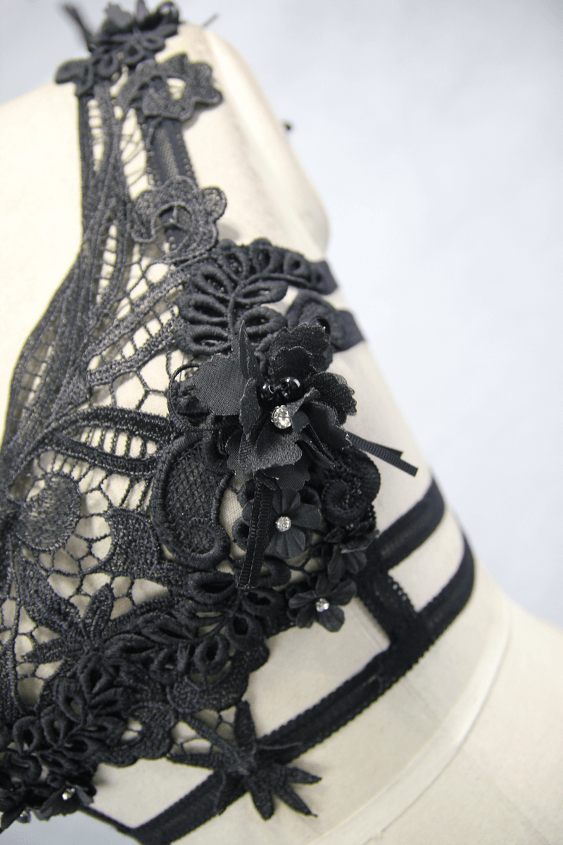 Close-up of women's gothic black guipure top with intricate lace and detachable feather details.