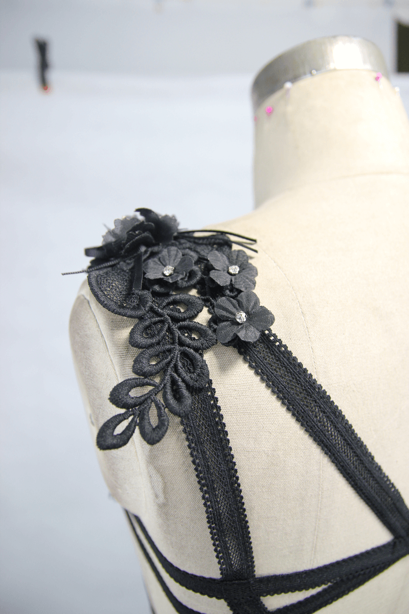 Close-up of a Gothic black guipure top shoulder with floral embellishments and straps.
