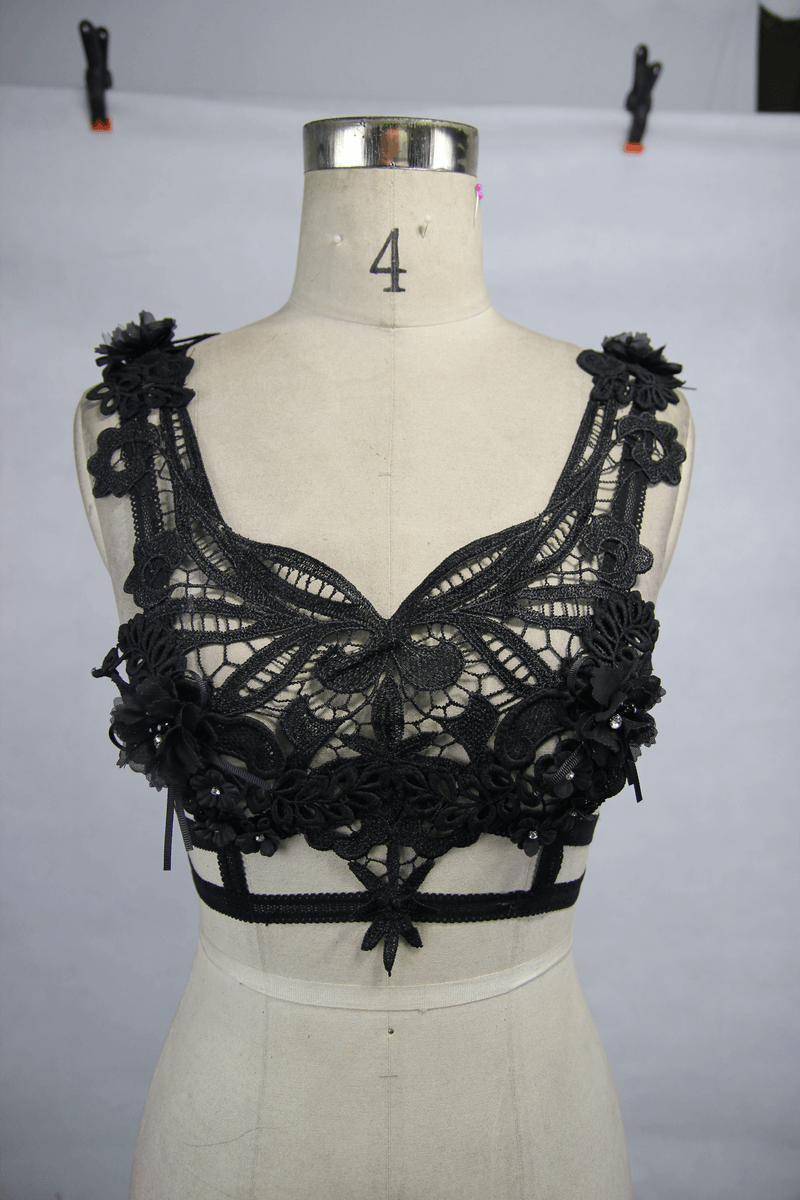 Gothic guipure black top with detachable feather accents and floral embellishments on mannequin.