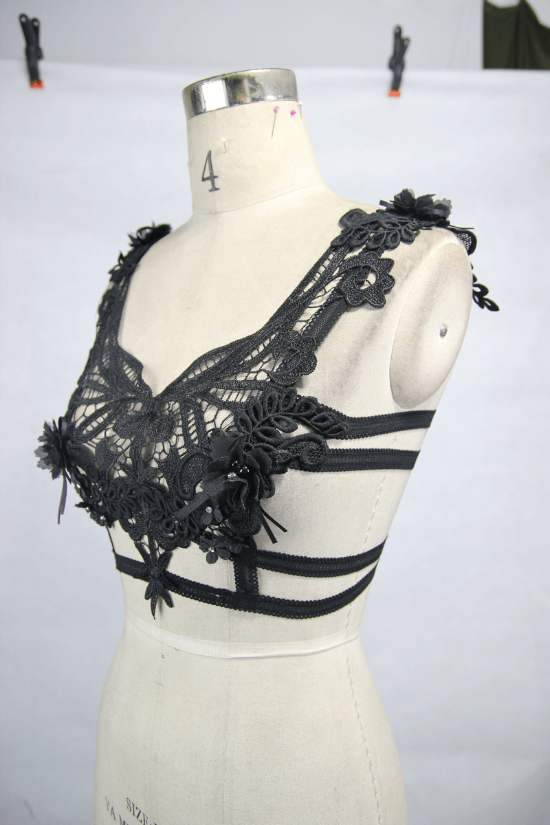 Gothic women's black guipure top with detachable feathers and floral detailing on a dress form.