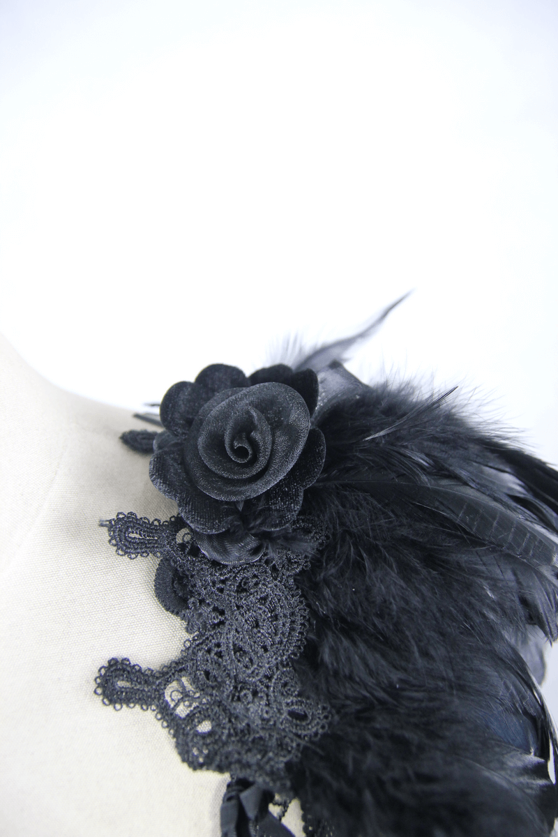 Close-up of black guipure top featuring lace and a decorative rose with feathers, showcasing gothic elegance.