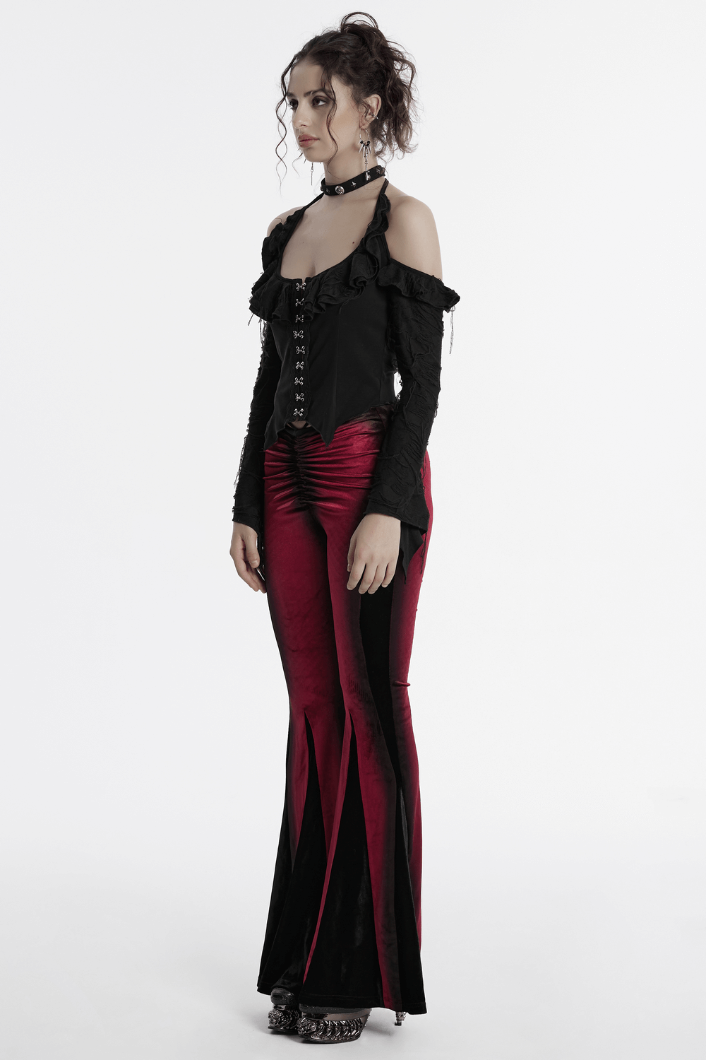 Model wearing Gothic halter top with ruffles, paired with red velvet flared pants, showcasing alternative fashion.