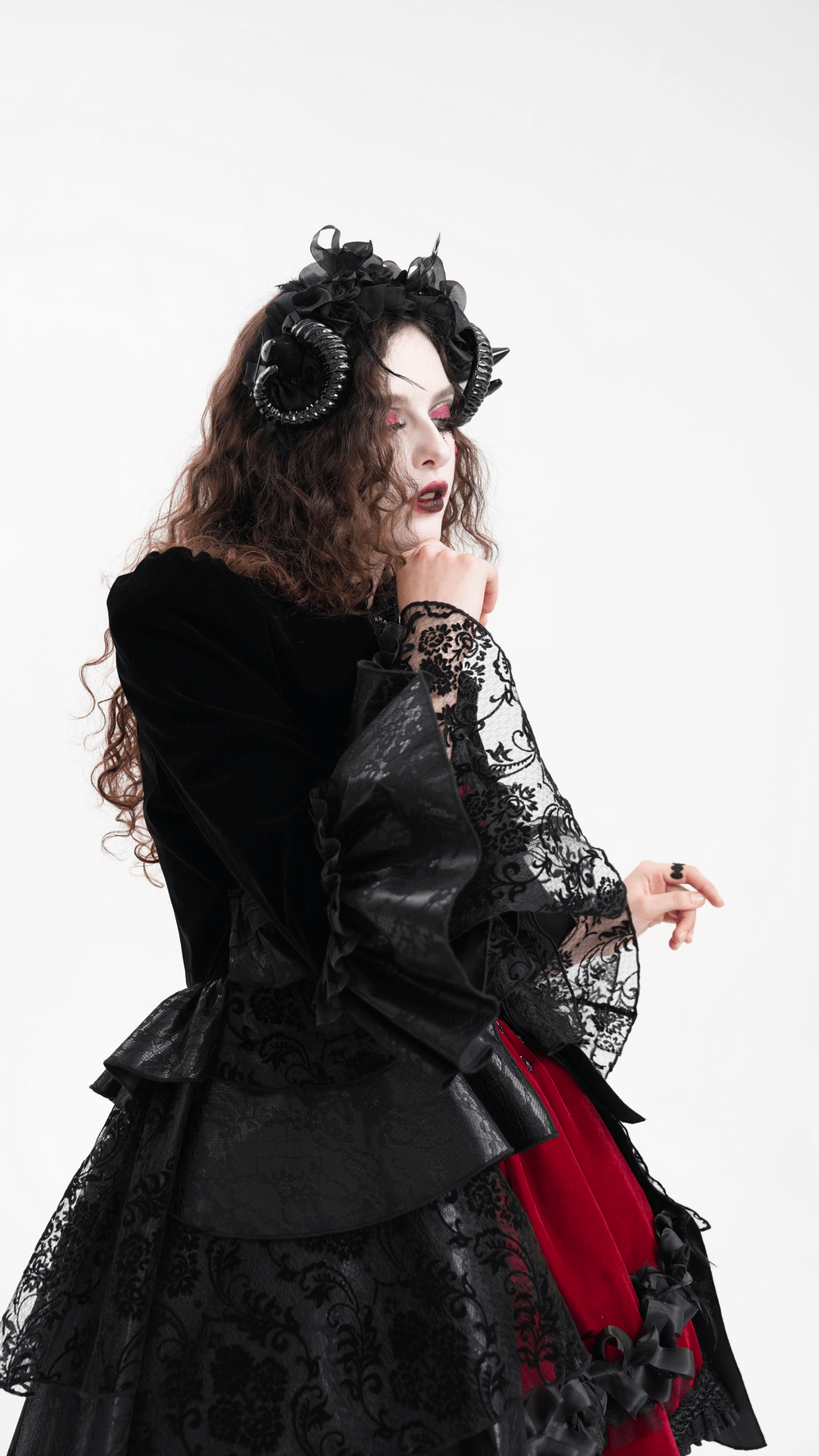 Gothic headpiece with horns and floral accents, worn by a model in dark elegant attire.