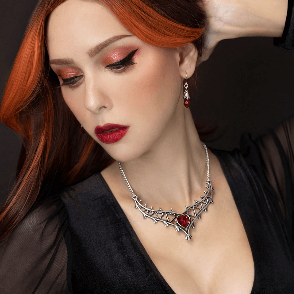 Gothic Heart Crystal Necklace With Ornate Tudor Design worn by a model, showcasing its intricate design and red crystal.