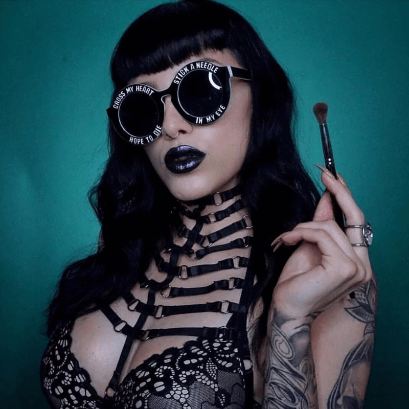 Gothic high collar garter bra model showcasing trendy fashion with unique sunglasses and makeup.