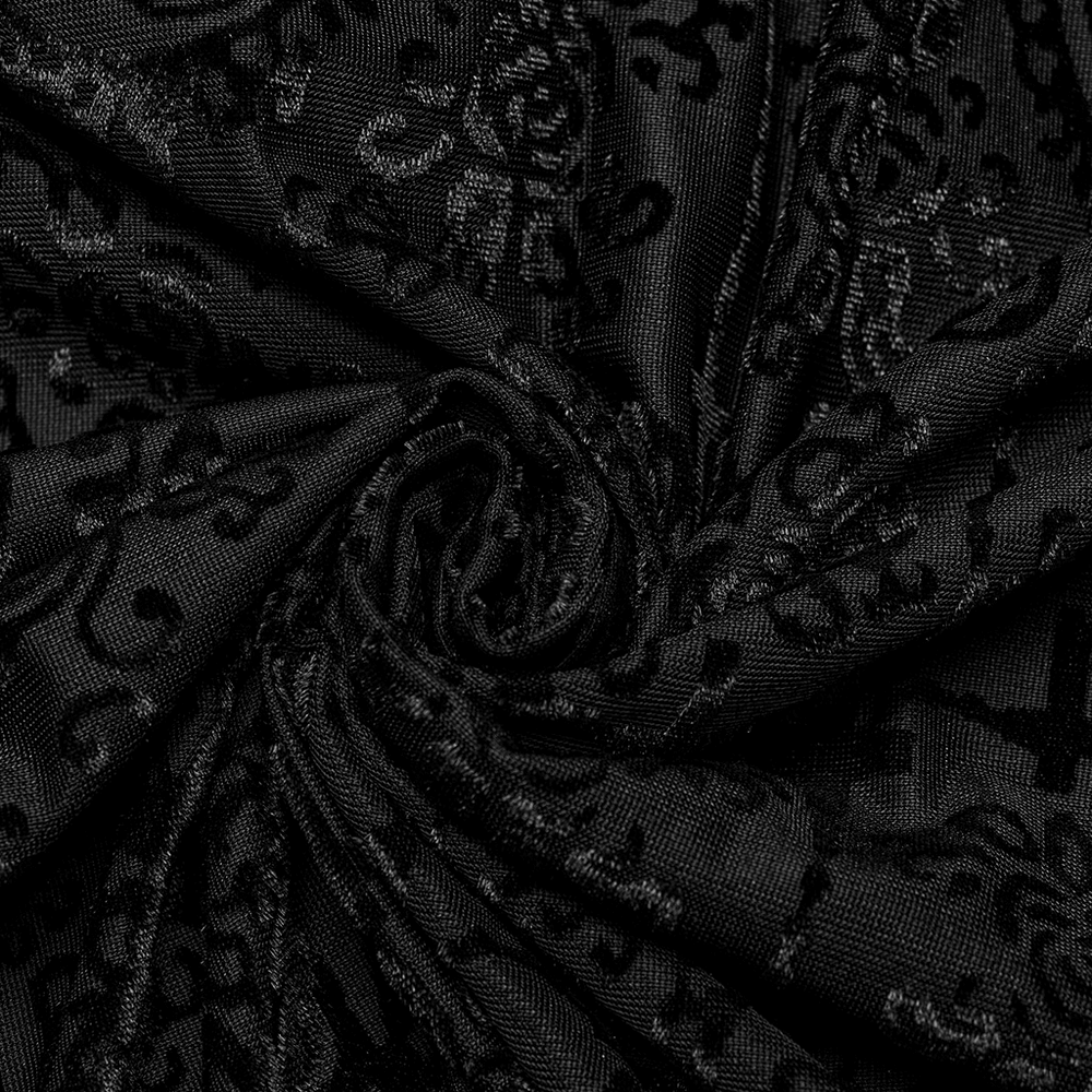 Close-up of elegant black fabric with embossed gothic floral patterns, showcasing rich texture and detail.