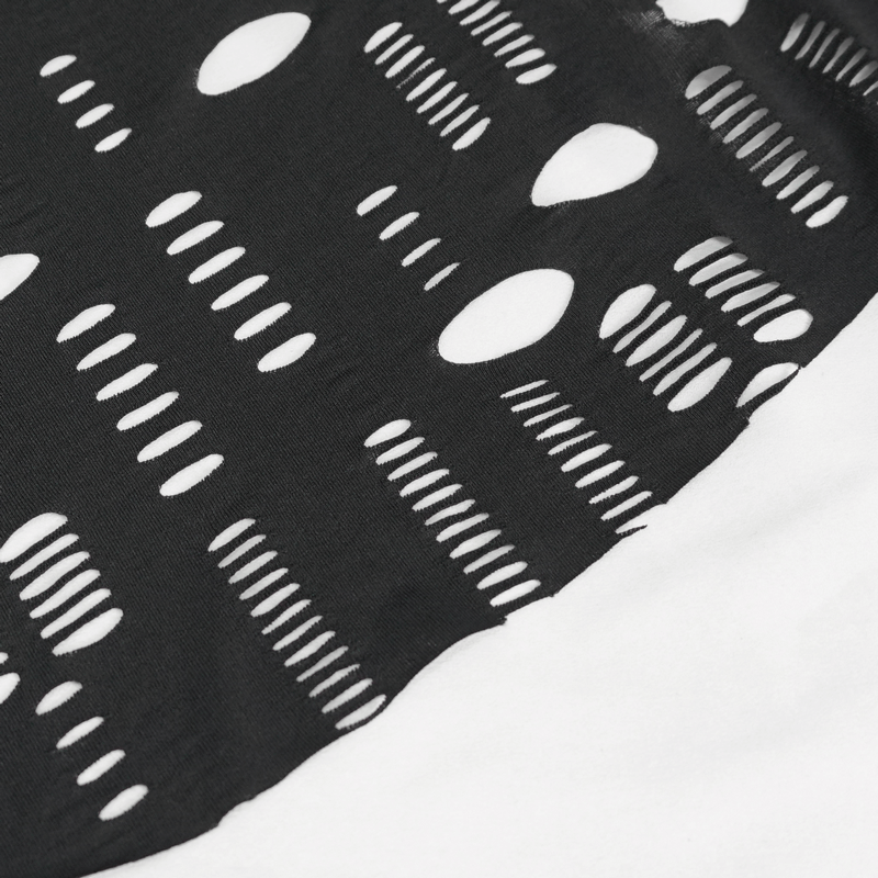 Close-up of black fabric with bold gothic holes, showcasing edgy design and modern style in off-the-shoulder top.