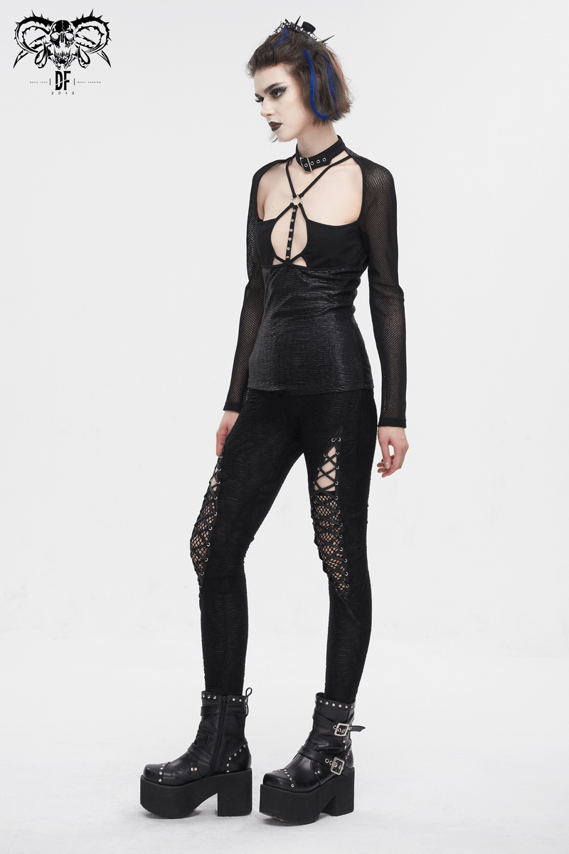 Bold woman in gothic hollow out lace-up leggings and edgy mesh top, showcasing dark elegance and style.