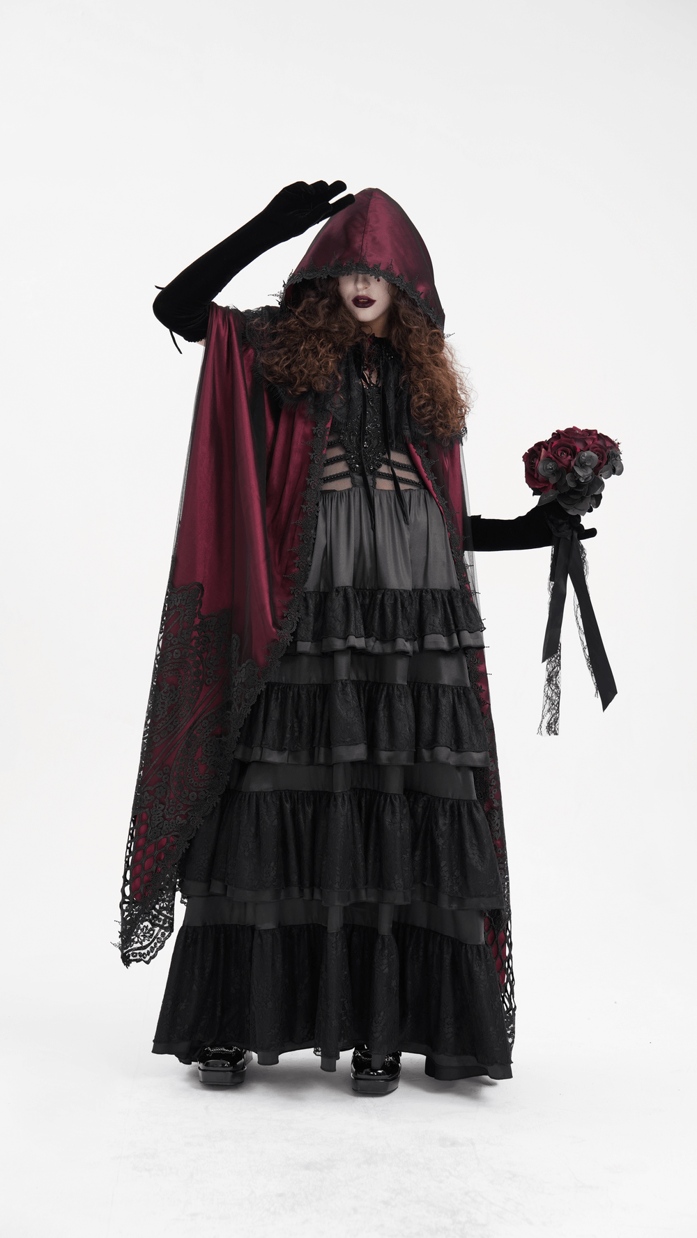 Gothic hooded cape with lace detailing, worn by a model holding flowers, showcasing dark elegance and style.