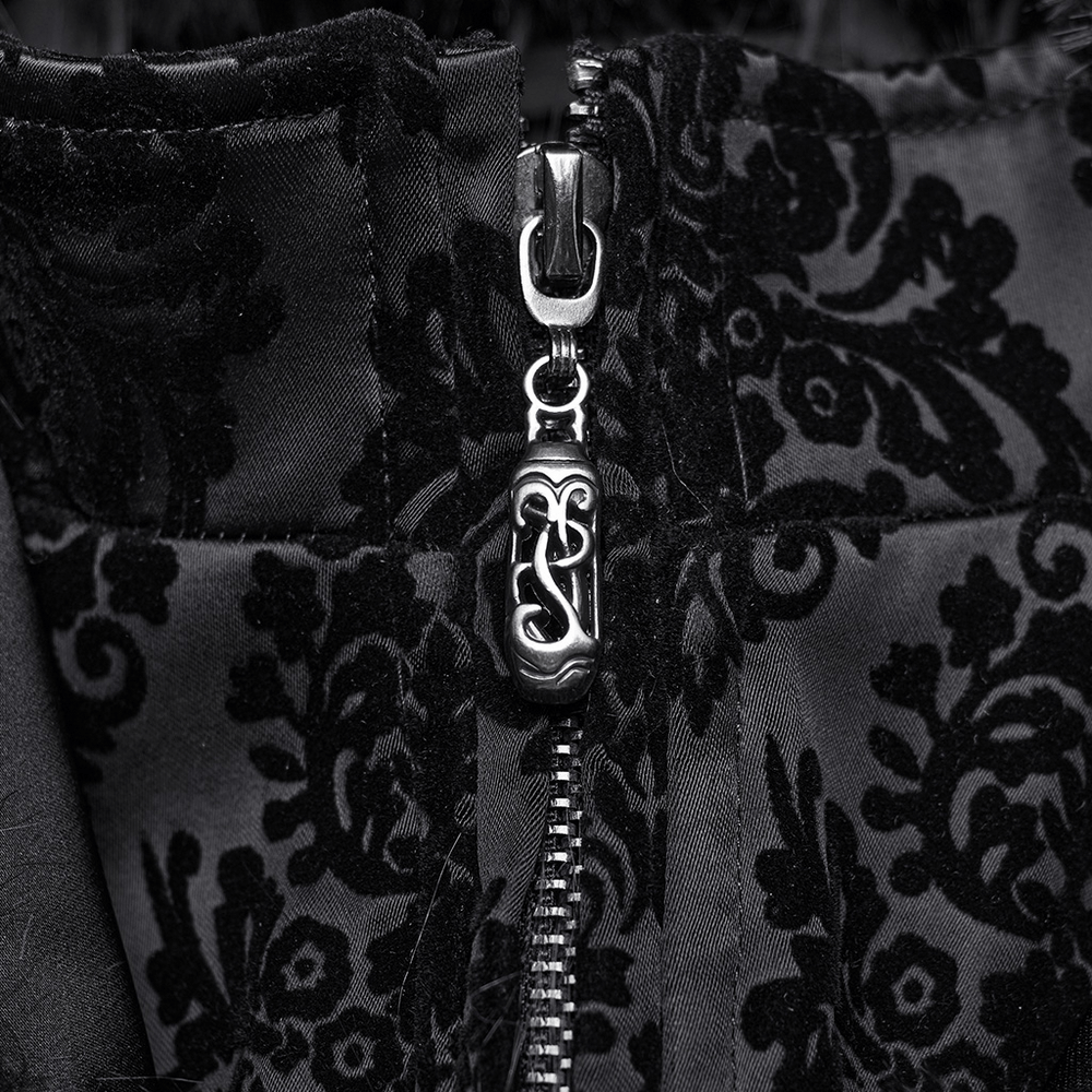 Close-up of zipper detail on gothic jacquard coat featuring ornate black fabric pattern and unique gemstone pull.