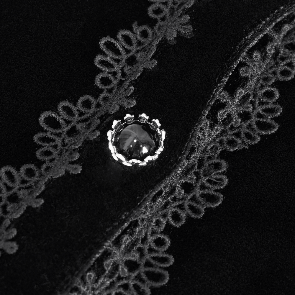Close-up of gothic velvet top featuring intricate lace trim and a decorative jewel button.