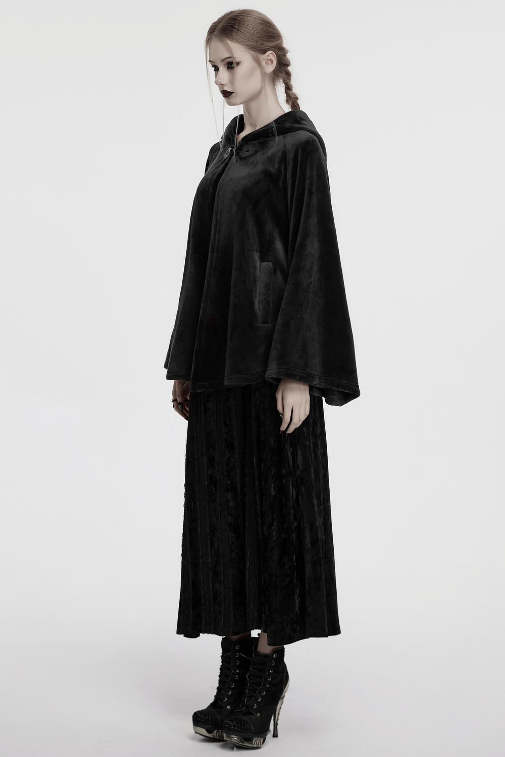 Gothic hooded velvet cape shown on a model, featuring dramatic flowing sleeves and a mysterious aura.