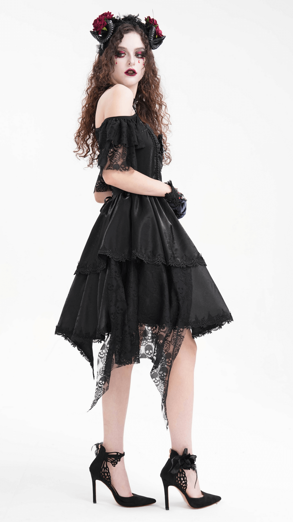 Gothic model wearing an off-shoulder black dress with lace details, black heels, and a floral horned headpiece.