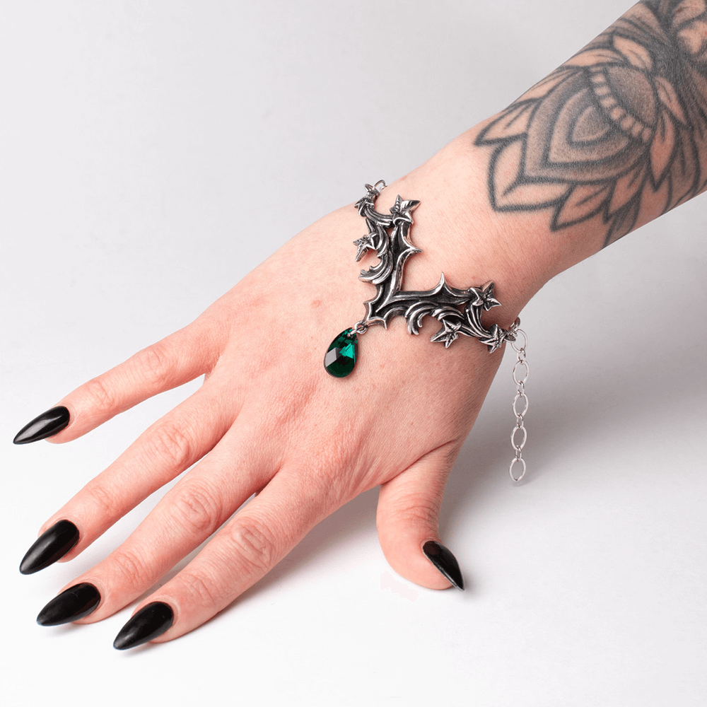 Gothic Ivy Bracelet with green crystal drop on a hand, featuring intricate ivy leaves and baroque design.