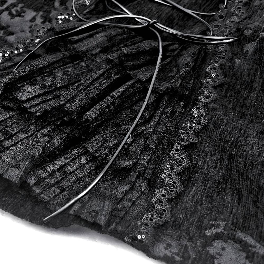 Close-up of gothic jacket featuring intricate lace trim and pleated velvet fabric with decorative silver accents.