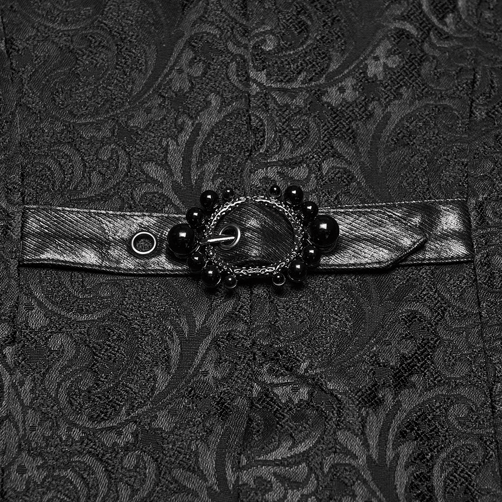Gothic Jacquard Asymmetric Jacket with Lace Details close-up of intricate buckle and strap on patterned fabric.