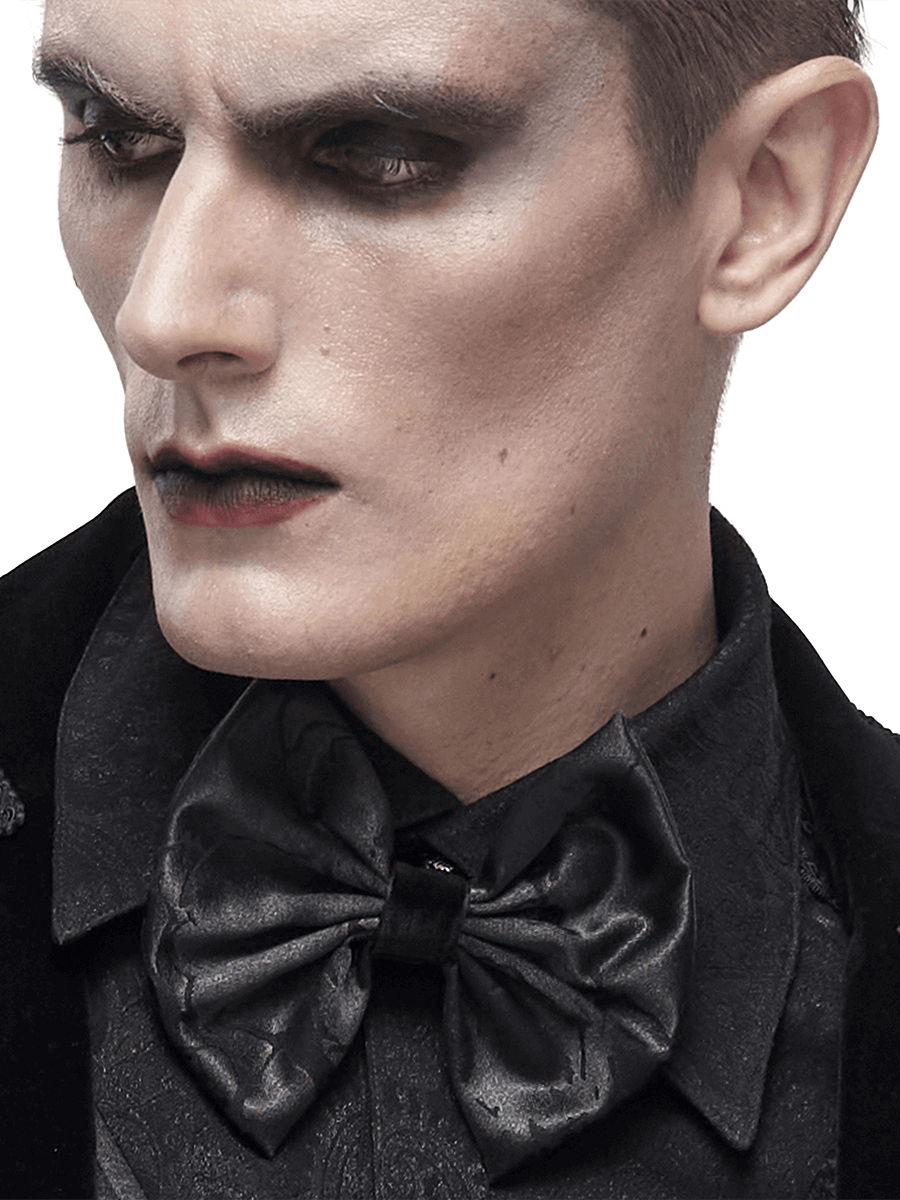 Close-up of a man wearing a gothic black bow tie, showcasing elegant style and dark fashion aesthetic.