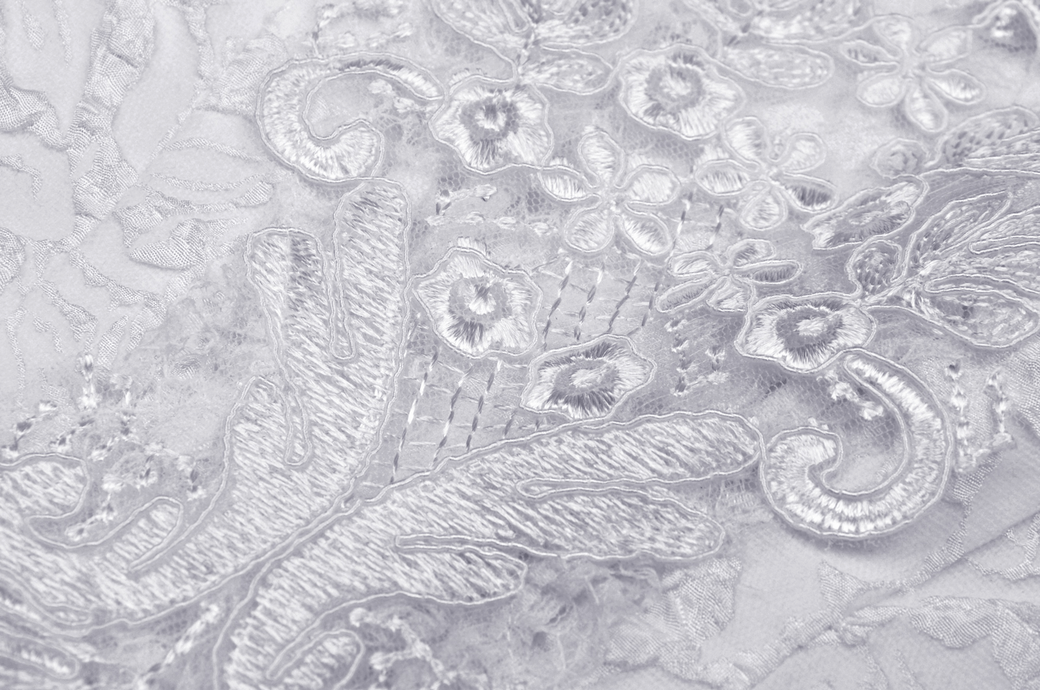Close-up of intricate floral embroidery on sheer fabric for a gothic wedding dress.