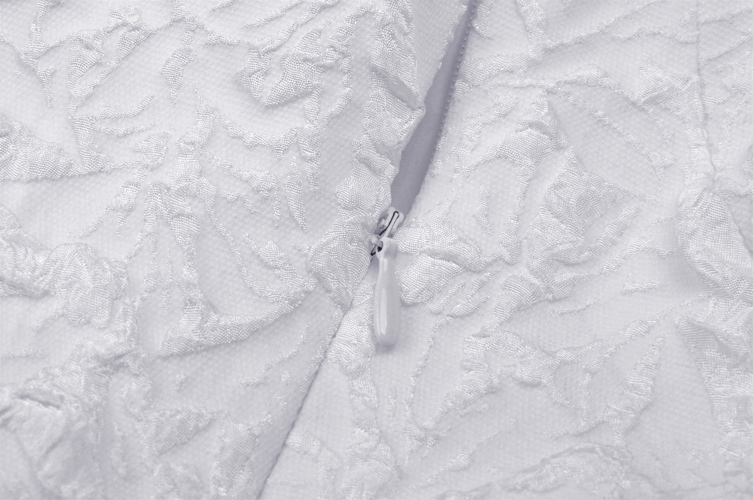 Close-up of the intricate embroidered fabric and zipper detail of a Gothic wedding dress.
